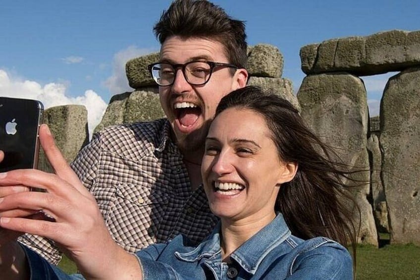 A person taking a selfie with Stonehenge in the background. 4