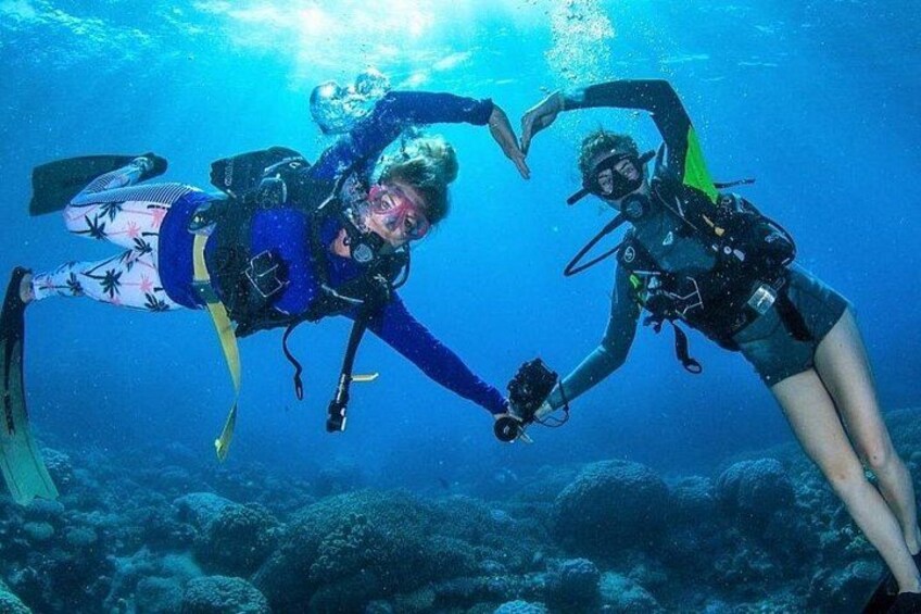 Two scuba divers underwater, surrounded by coral reefs. 2