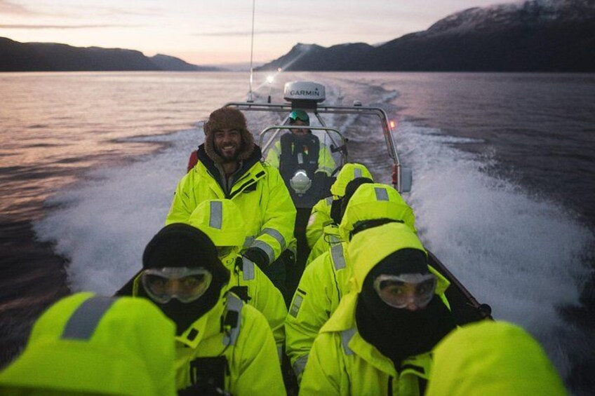 Un grupo de personas con chalecos amarillo brillante en un barco, con un paisaje montañoso al fondo. 5