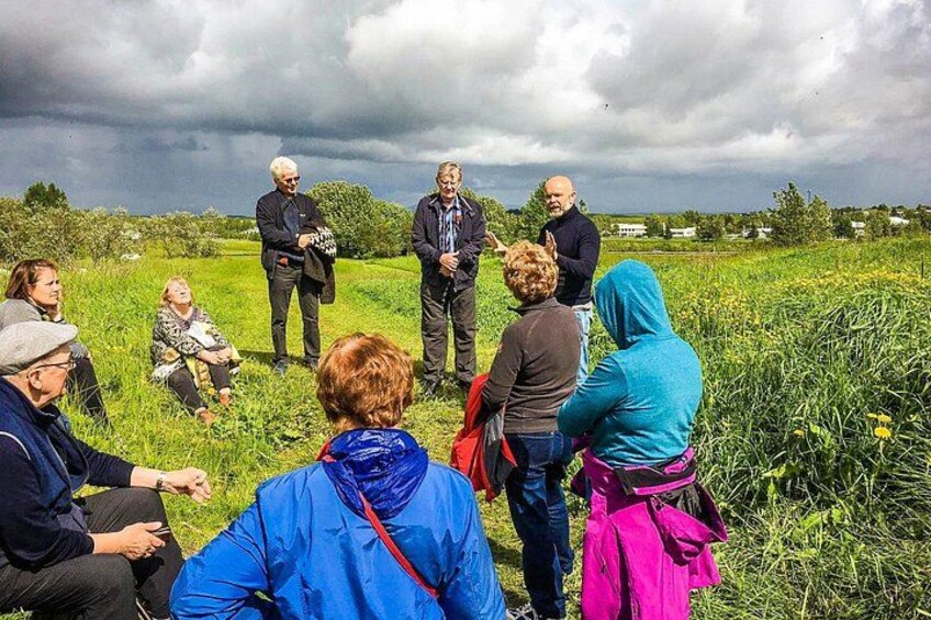 A group of people standing in a field, some facing away from the camera. 3