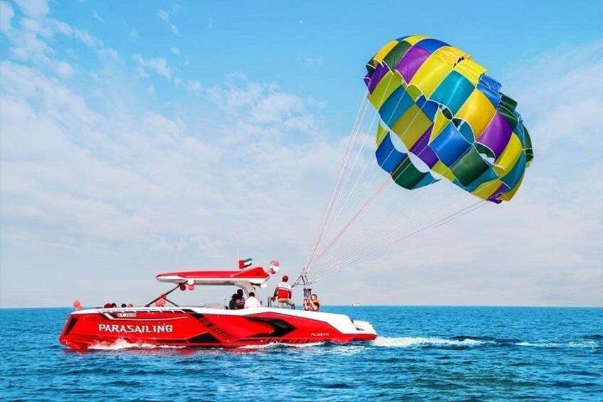 Un bateau de parachute ascensionnel avec un parachute aux couleurs vives au-dessus de l’eau. 2