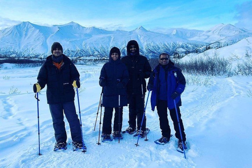 Cuatro personas esquiando en una montaña nevada con cielo despejado. 2