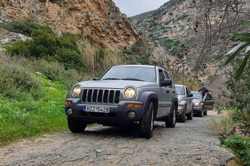 A Jeep on a gravel road with a rocky hillside in the background. 3