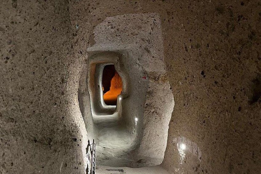 A cave entrance with a rough, textured wall and a small opening. 1