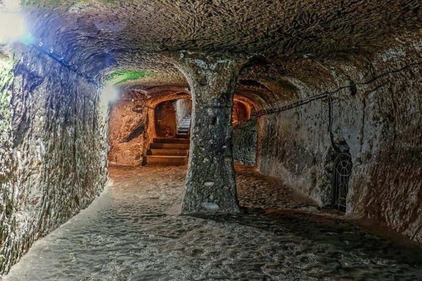 An underground passage with stone walls, a staircase, and a hanging lantern. 4
