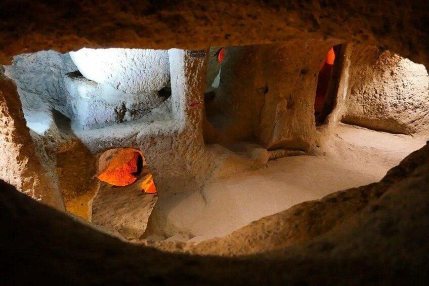 A cave with stalactites, a rock formation, and a cave opening. 2
