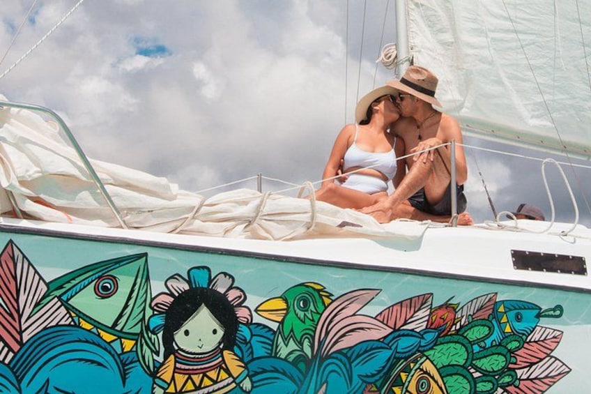 A couple on a sailboat with a colorful fish mural. 5