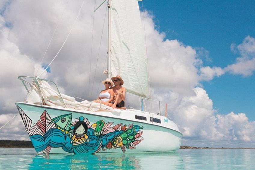 A sailboat with colorful artwork on its side, sailing on calm waters. 1