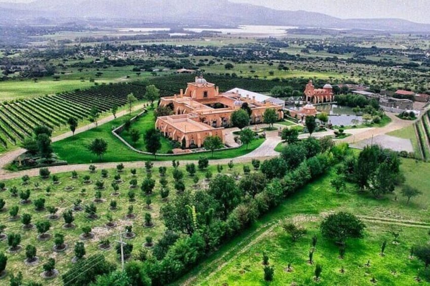 A large estate with expansive gardens and a prominent red-roofed building. 1