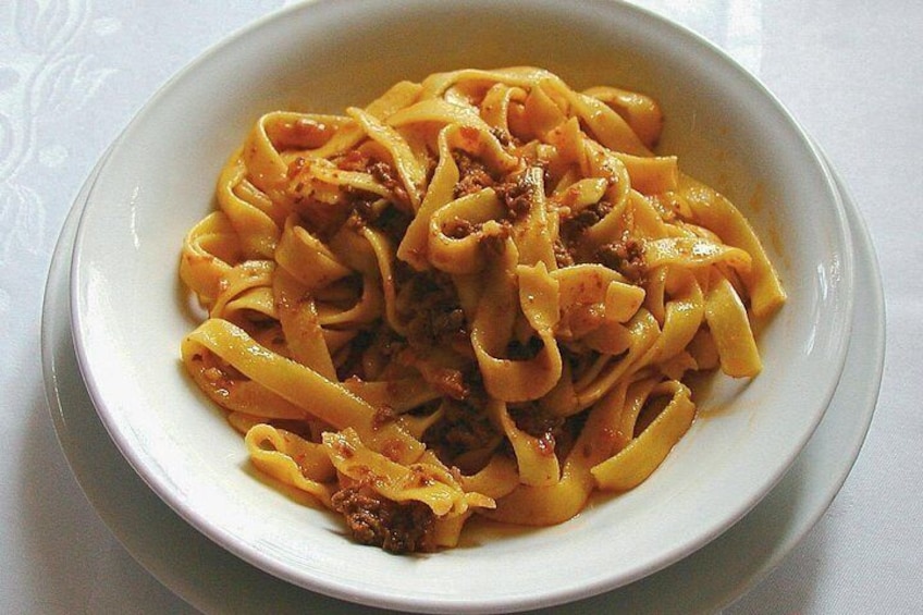 En tallrik pasta med en tomatsås och köttfärs. 5