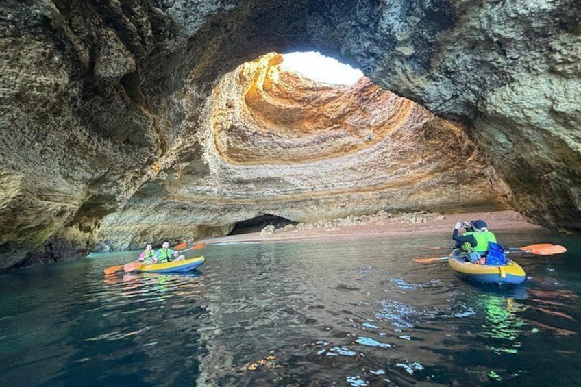 Des kayakistes naviguent dans une grotte, au-dessus de laquelle se trouve une importante formation rocheuse. 3