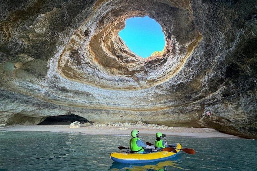 En person som åker kajak i en grotta med en cirkelformad öppning. 1