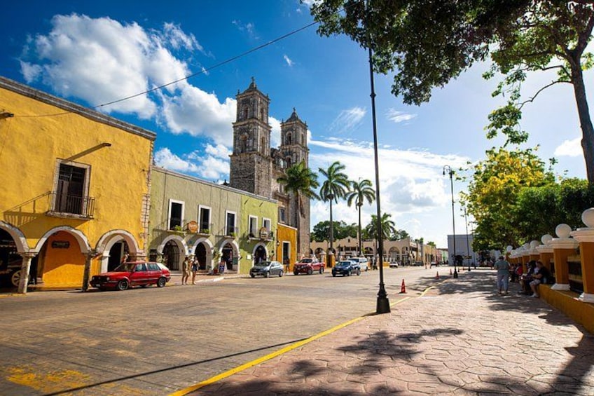 Calle con edificios, una iglesia, palmeras y cielo despejado. 3