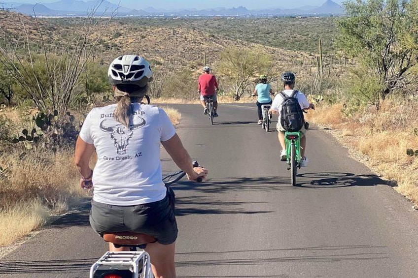 A paved road with cyclists in a desert landscape. 2