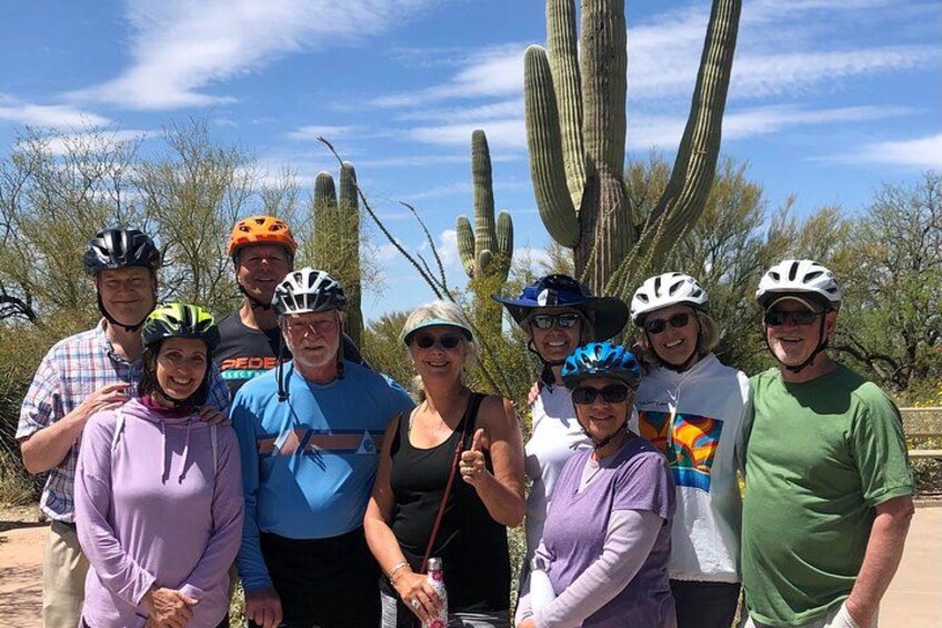 A group of people wearing helmets, standing in front of cacti. 1
