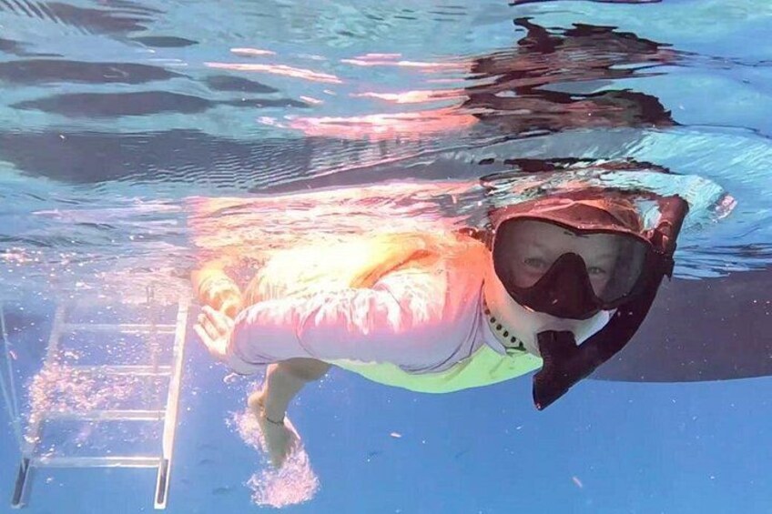 A person swimming underwater in a pool. 2