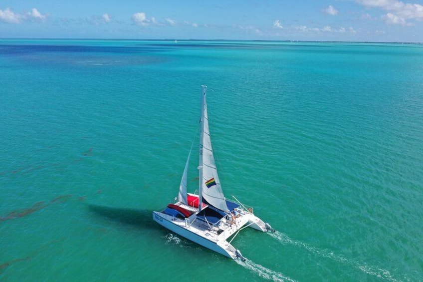 A sailboat on turquoise water with a clear sky. 2