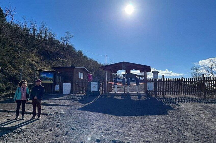 Una entrada rural con cerca de madera, un porche cubierto y un camino de tierra. 4