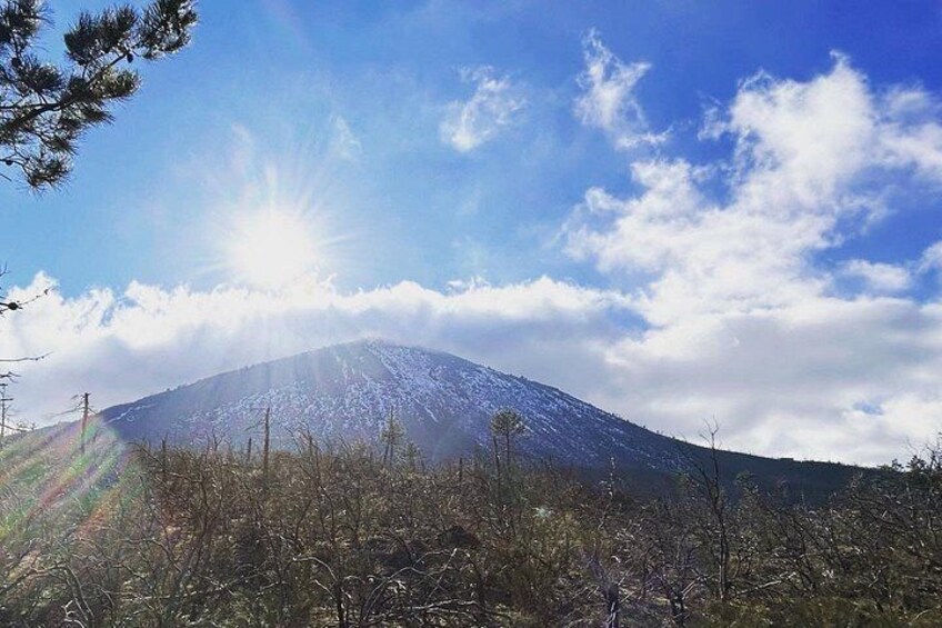 Una montaña nevada con el sol brillando entre las nubes. 5