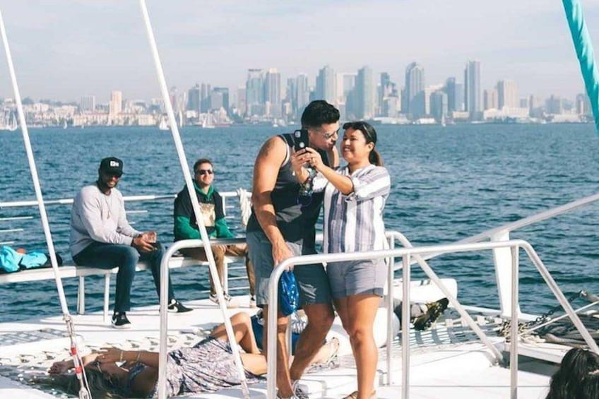 A group of people on a boat with a city skyline in the background. 2