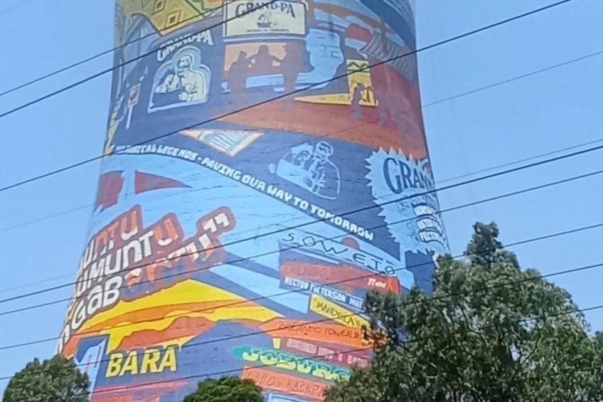 Une fresque colorée orne une structure cylindrique et présente diverses publicités et textes. 5