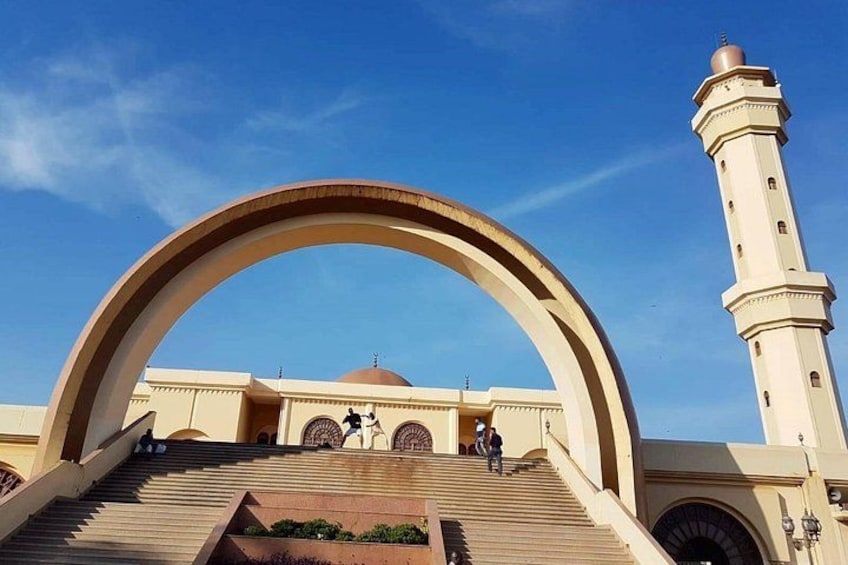 Una mezquita con un amplio arco y un minarete. 1