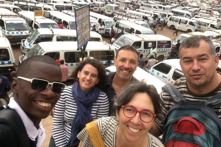 A group of people in an outdoor setting with multiple white vans parked in rows. 2