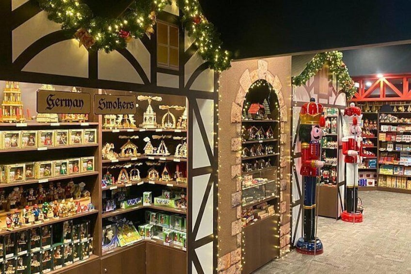 Una tienda con decoraciones navideñas, incluyendo espantapájaros de madera y un letrero que dice 'German'. 2