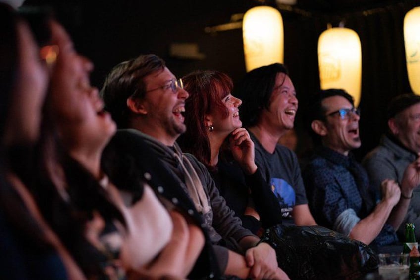 A group of people seated in a dimly lit room with hanging lanterns. 4