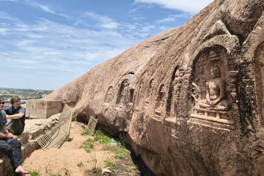 A large rock with ancient carvings, including statues and architectural designs. 5