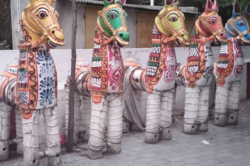 A row of colorful, intricately decorated horse statues. 3