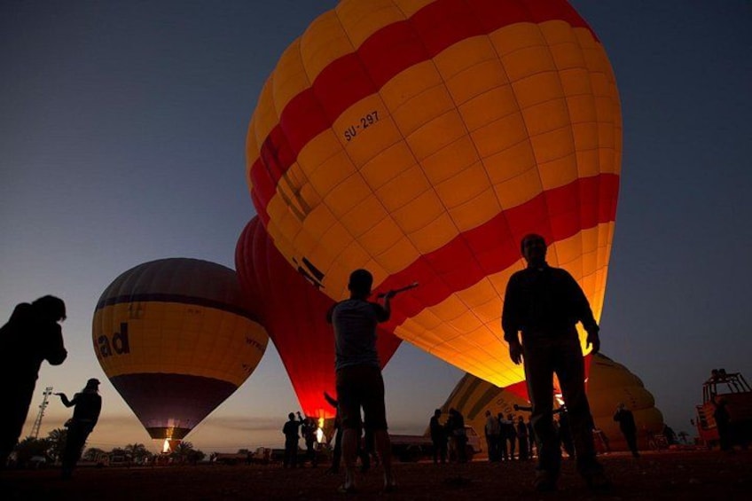 Hot air balloons with people preparing them. 2