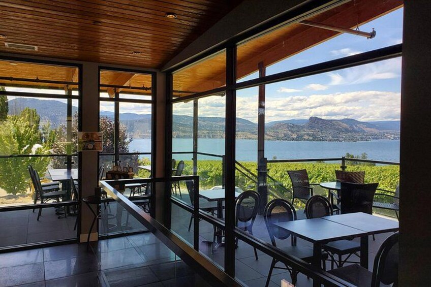 Un espace de restauration moderne doté de grandes fenêtres donnant sur un lac et des montagnes. 2