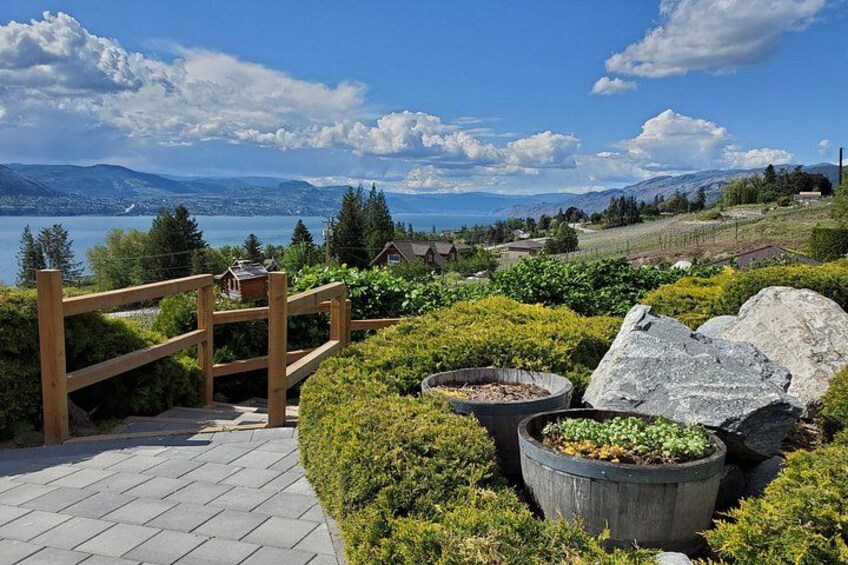 Une porte en bois, des plantes en pot et une vue panoramique sur un lac, avec des montagnes en arrière-plan. 4
