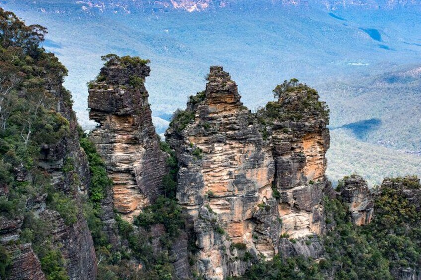 A canyon with tall rock formations and dense green vegetation. 2