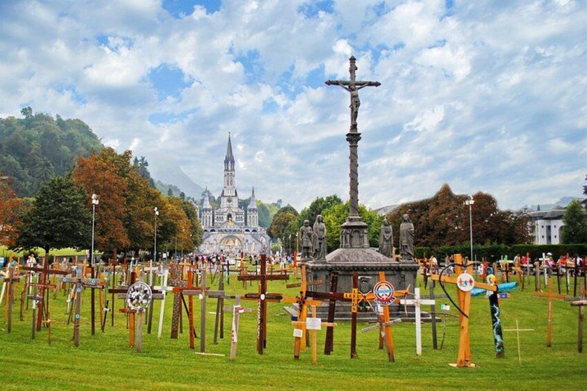 A cemetery with gravestones, a central monument, and a church in the background. 4