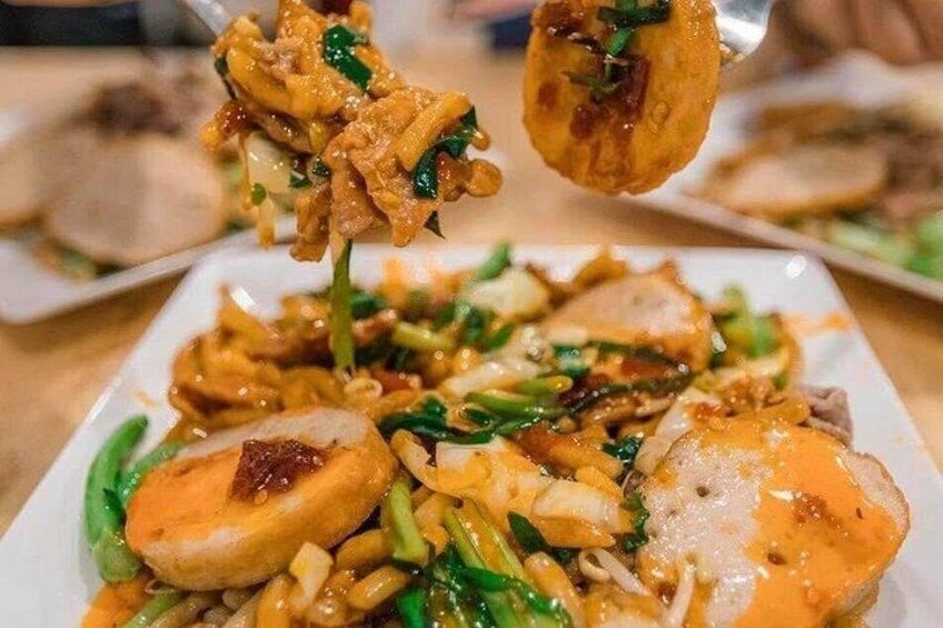 A dish with sliced meat, vegetables, and a sauce. 2