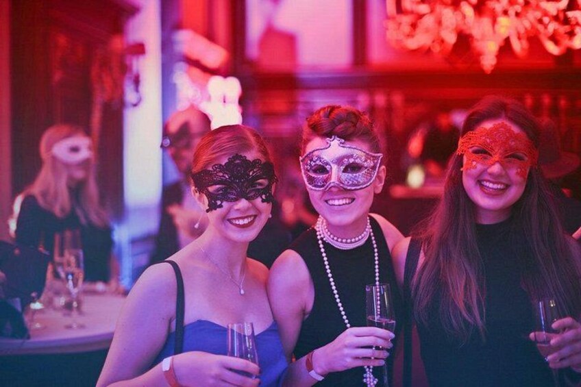 Three people at a social event, holding drinks. 5