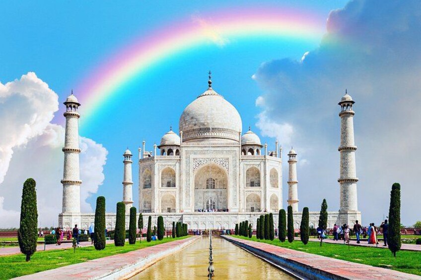 The Taj Mahal with a rainbow in the sky, surrounded by manicured gardens and minarets. 1
