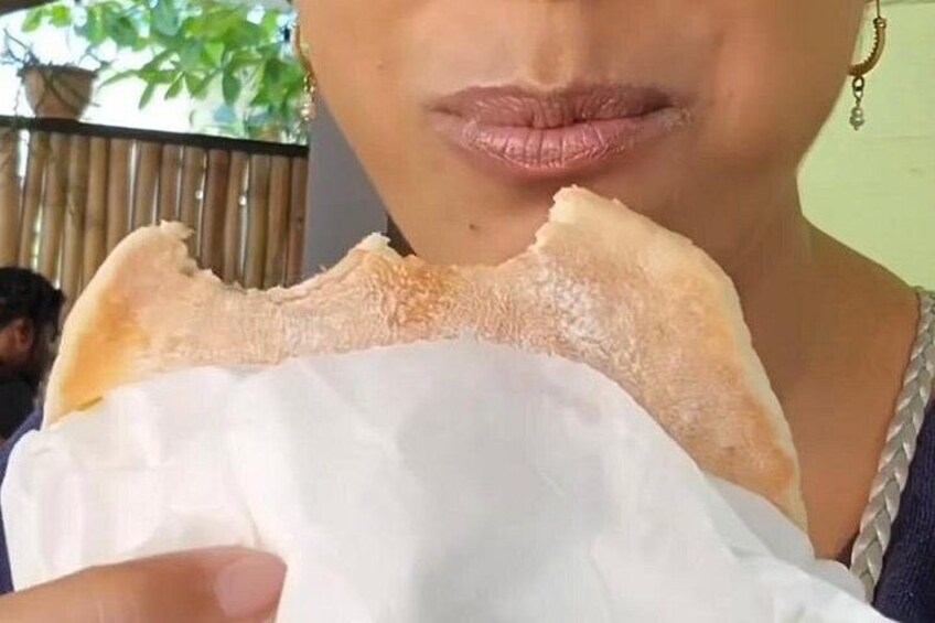 Una persona che tiene in mano un pezzo di pane con un tovagliolo bianco. 1