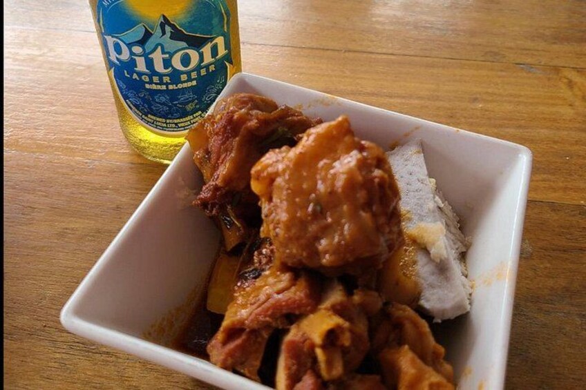 Una ciotola bianca con pollo fritto e una bottiglia di birra lager Piton su un tavolo di legno. 2