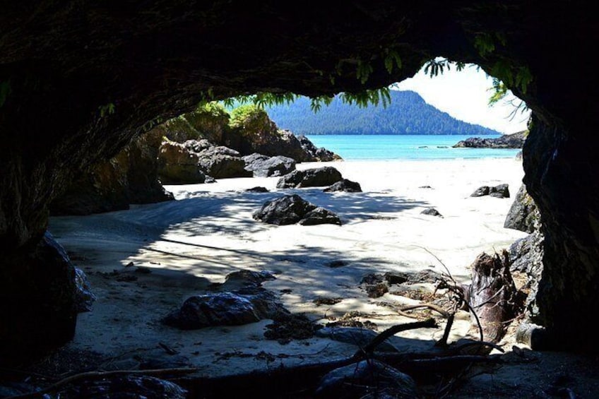 A beach with rocks and a cave entrance. 3