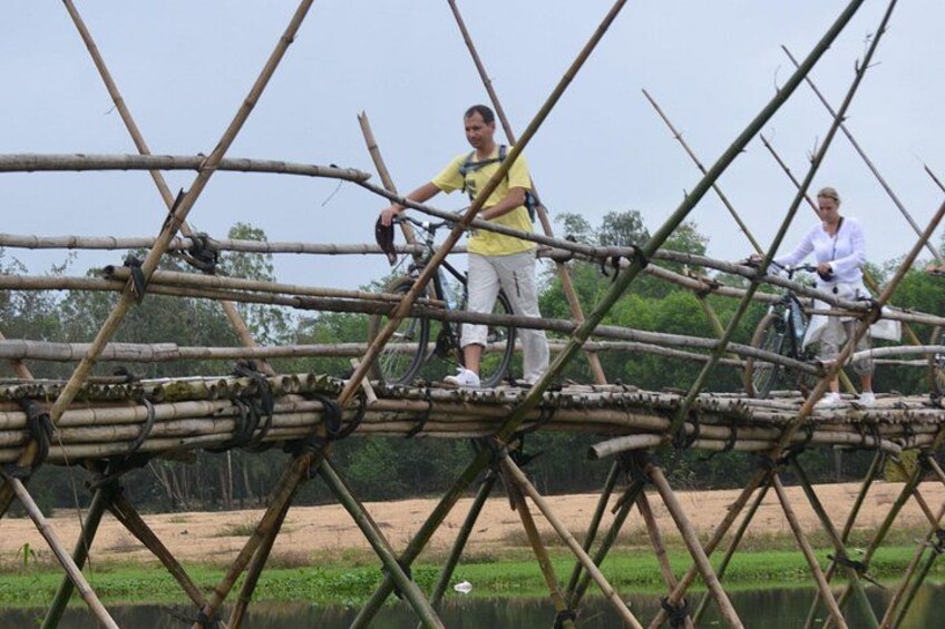 A bamboo bridge with people crossing it. 4