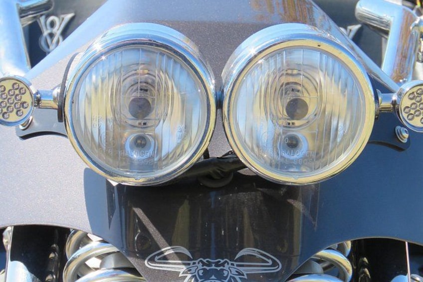 A close-up of a vehicle's front with dual headlights and chrome accents. 5