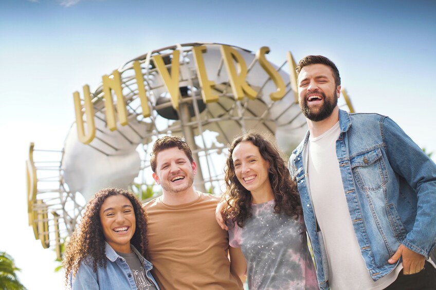 Un grup de persones al costat d'un gran rètol que diu 'UNIVERSAL'. 1