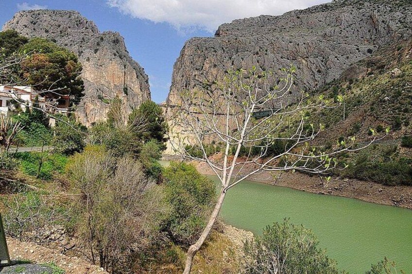 A mountainous landscape with a river, rocky cliffs, and sparse vegetation. 3