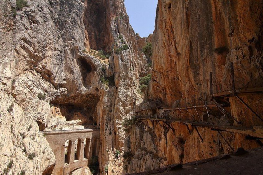 A rocky canyon with a narrow passageway and a bridge. 4