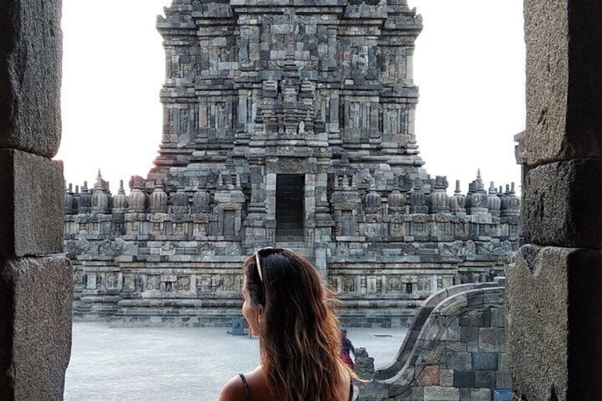 A woman looking at a large stone temple with intricate carvings. 3
