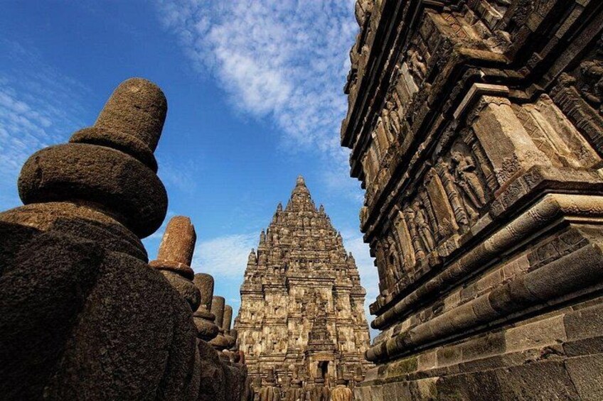 Een stenen tempel met gedetailleerde gravures en een helderblauwe lucht. 2