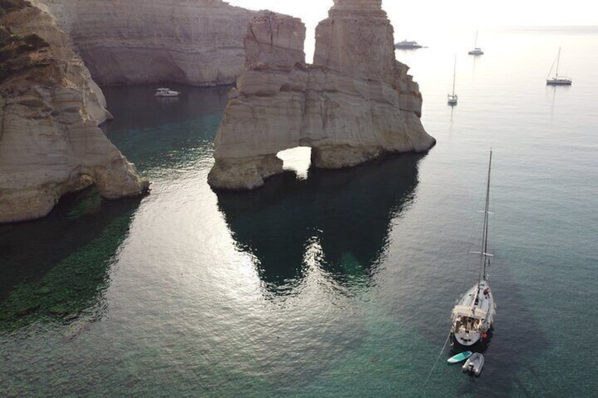 Una zona costera con aguas transparentes, acantilados rocosos y barcos anclados cerca de la orilla. 5